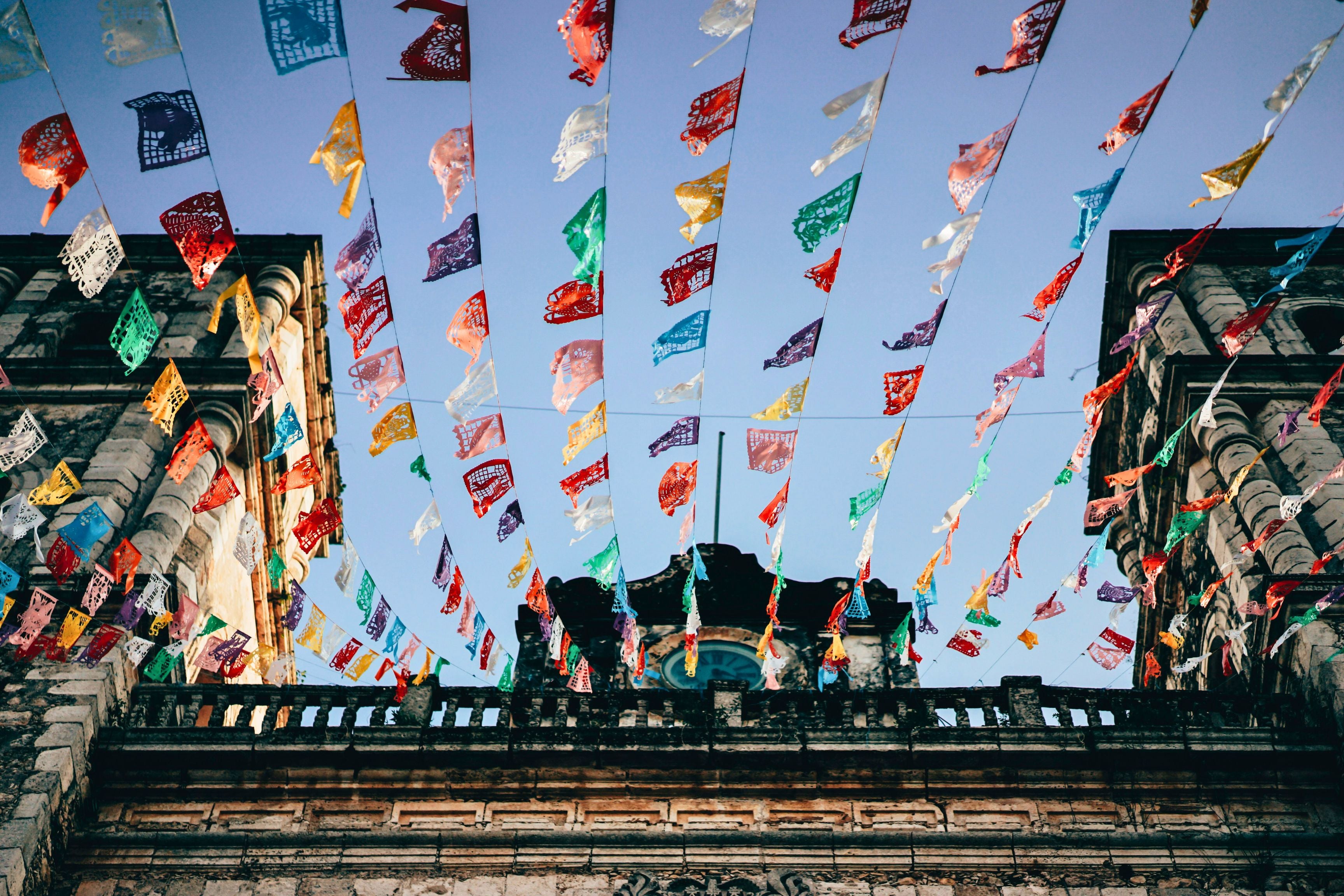 colorful mexican banners hanging from old building