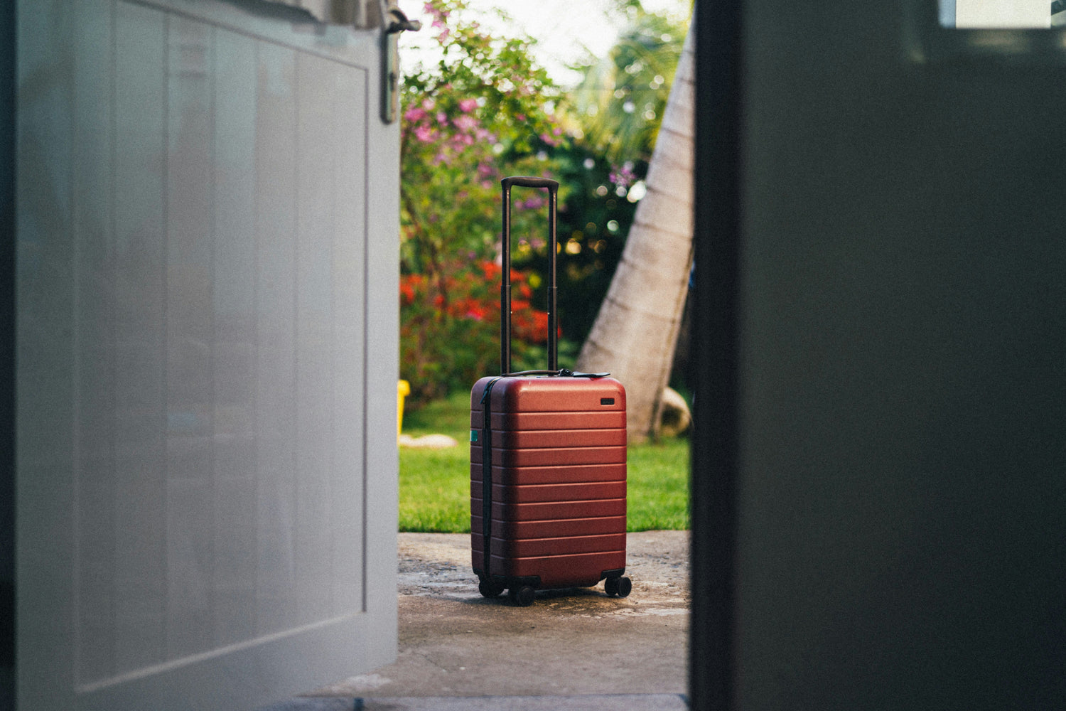 A travel suitcase sitting outside the door