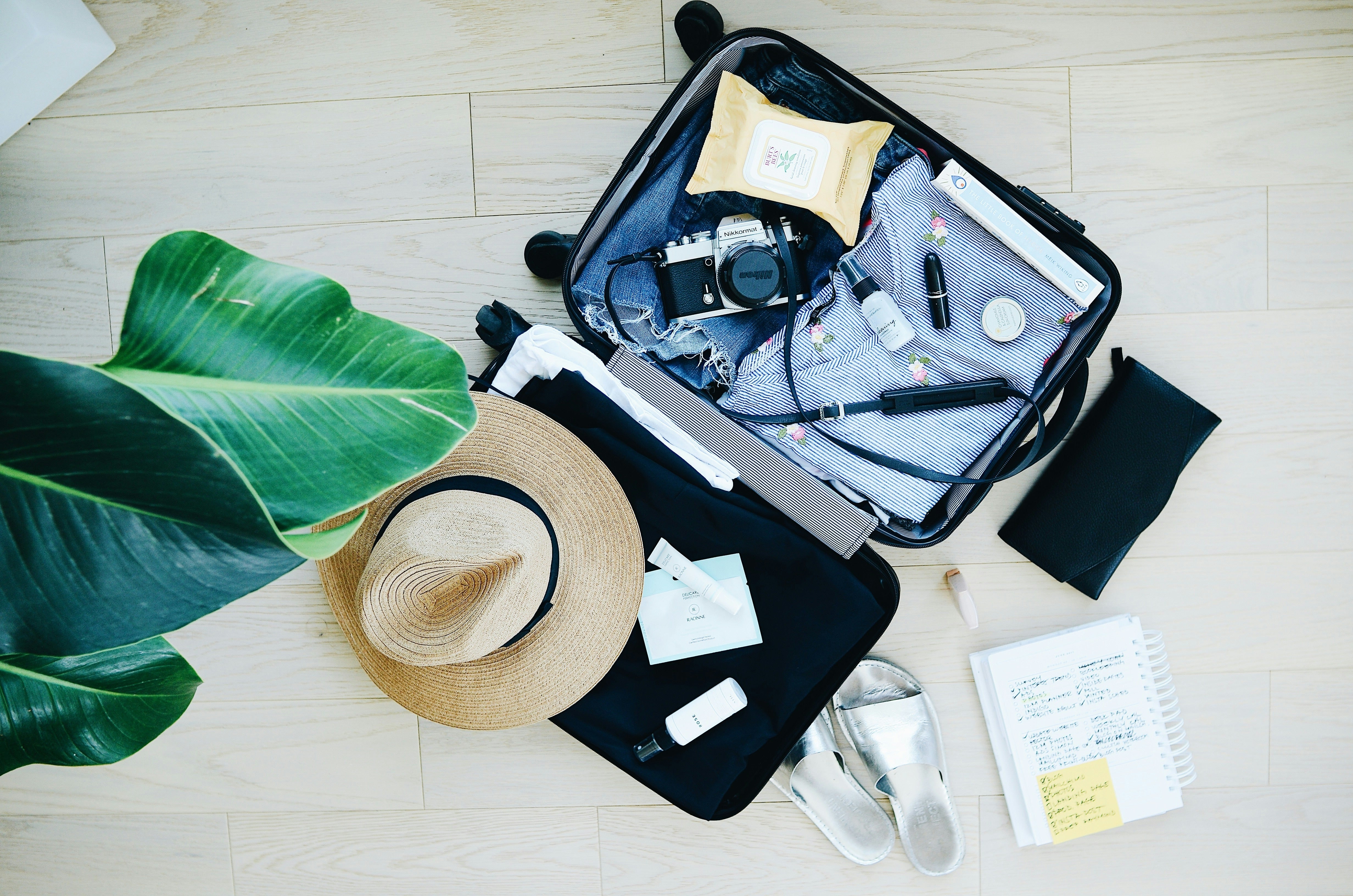 Woman on an airplane after a long flight with her backpack of airport essentials including a travel blanket